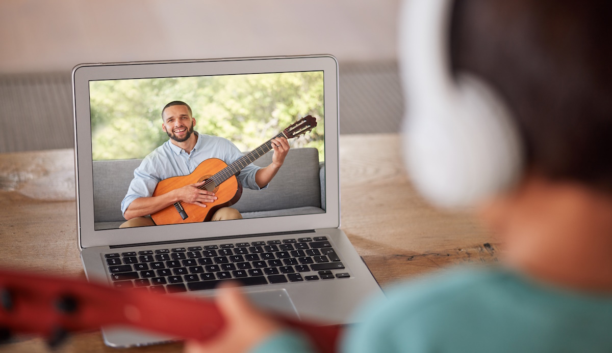 Learning guitar, video call and instructor teaching a girl an instrument, live streaming a class an.